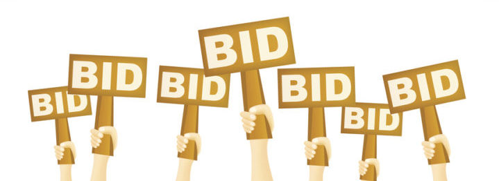 Hands holding BID sign to buy from auction.