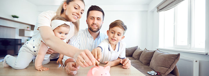 A smiling family saves money with a piggy bank
