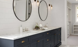 Bathroom in New Luxury Home with Two Sinks and Dark Blue Cabinets. Shows Walk-In Closet