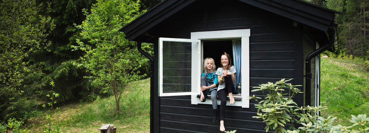 Girls sitting in window of shack
