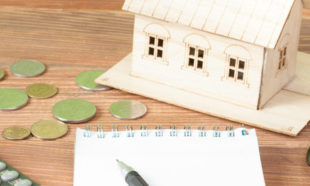 Home savings, budget concept. Model house, notepad, pen, calculator and