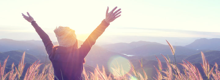 Happy Woman Enjoying Nature on meadow on top of mountain with sunrise. Outdoor. Freedom concept.