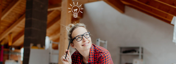 young, pretty, blonde woman is planning on the notebook and tablet the expansion of her loft and a light goes on her