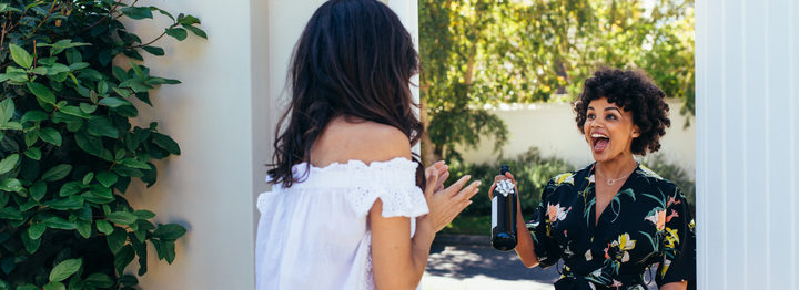 Excited woman with wine bottle for housewarming party