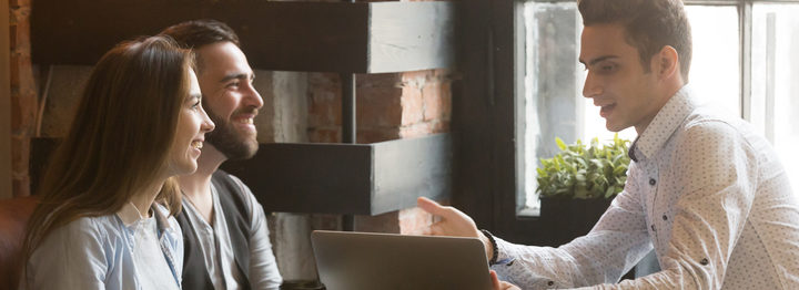 Insurance broker or salesman making offer to couple in cafe