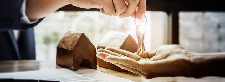 estate agent giving house keys of customer and holding dollar us bank at agency office. agreement concept.