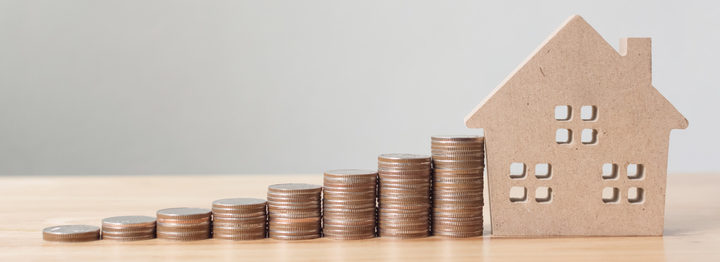 Property investment and house mortgage financial concept, Hand putting money coin stack with wooden house
