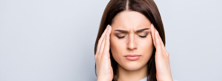 Portrait of upset, sad, pretty, nice, charming, stylish woman in shirt having head ache, stress, troubles, touching temples with fingers and close eyes, standing over grey background