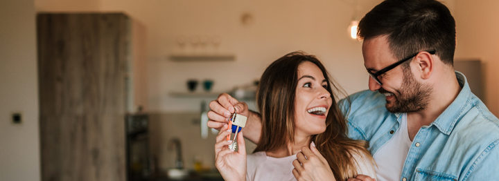 Young man surprising his wife or a girl with new a apartment.