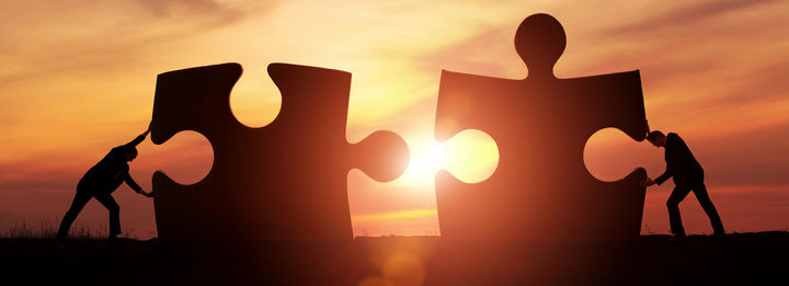 Two businessman connecting puzzle pieces togheter with copy space