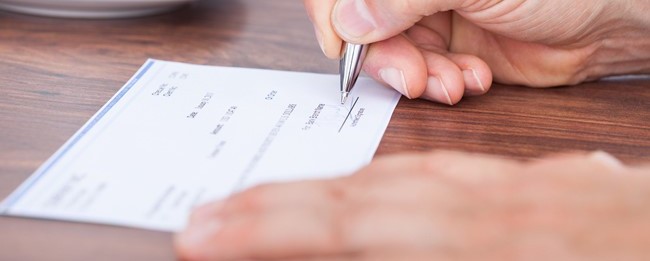 property manager completing a security deposit check to send to tenant