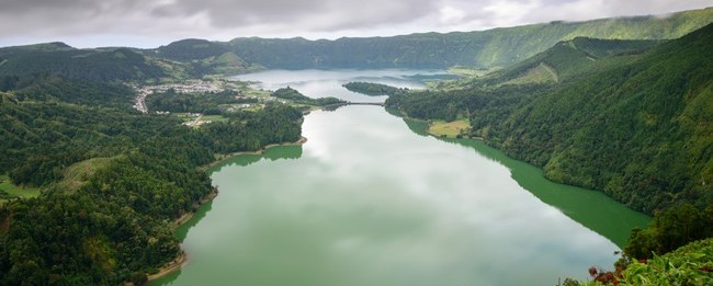 green mountains surrounding green lake