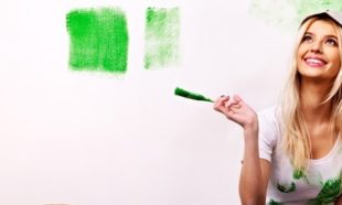 woman painting wall green