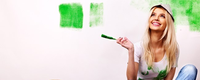 woman painting wall green